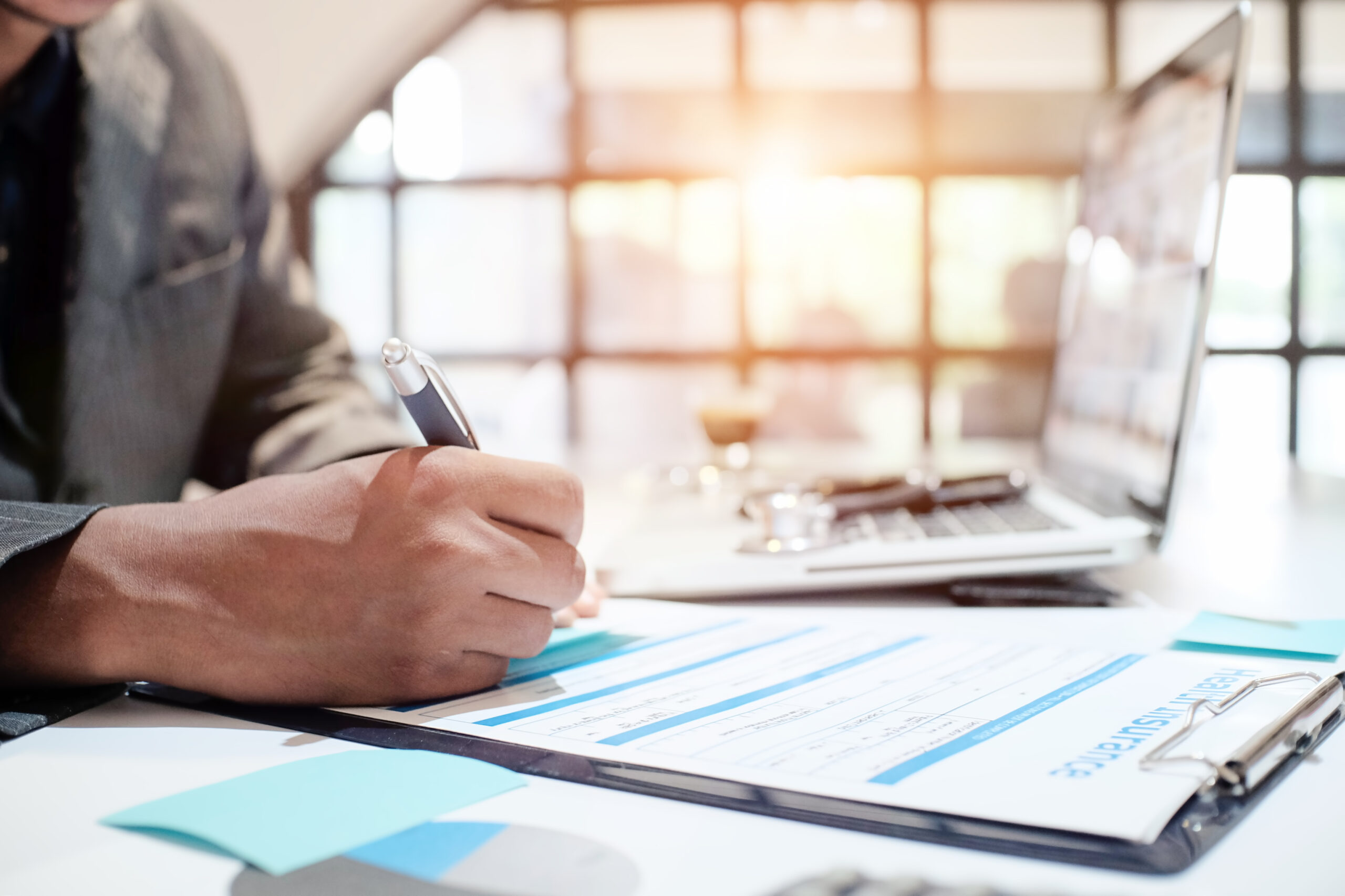 Insurance agent holding pen medical insurance, the policy and explain insurance policy to customer. life insurance concept. Filling out paperwork